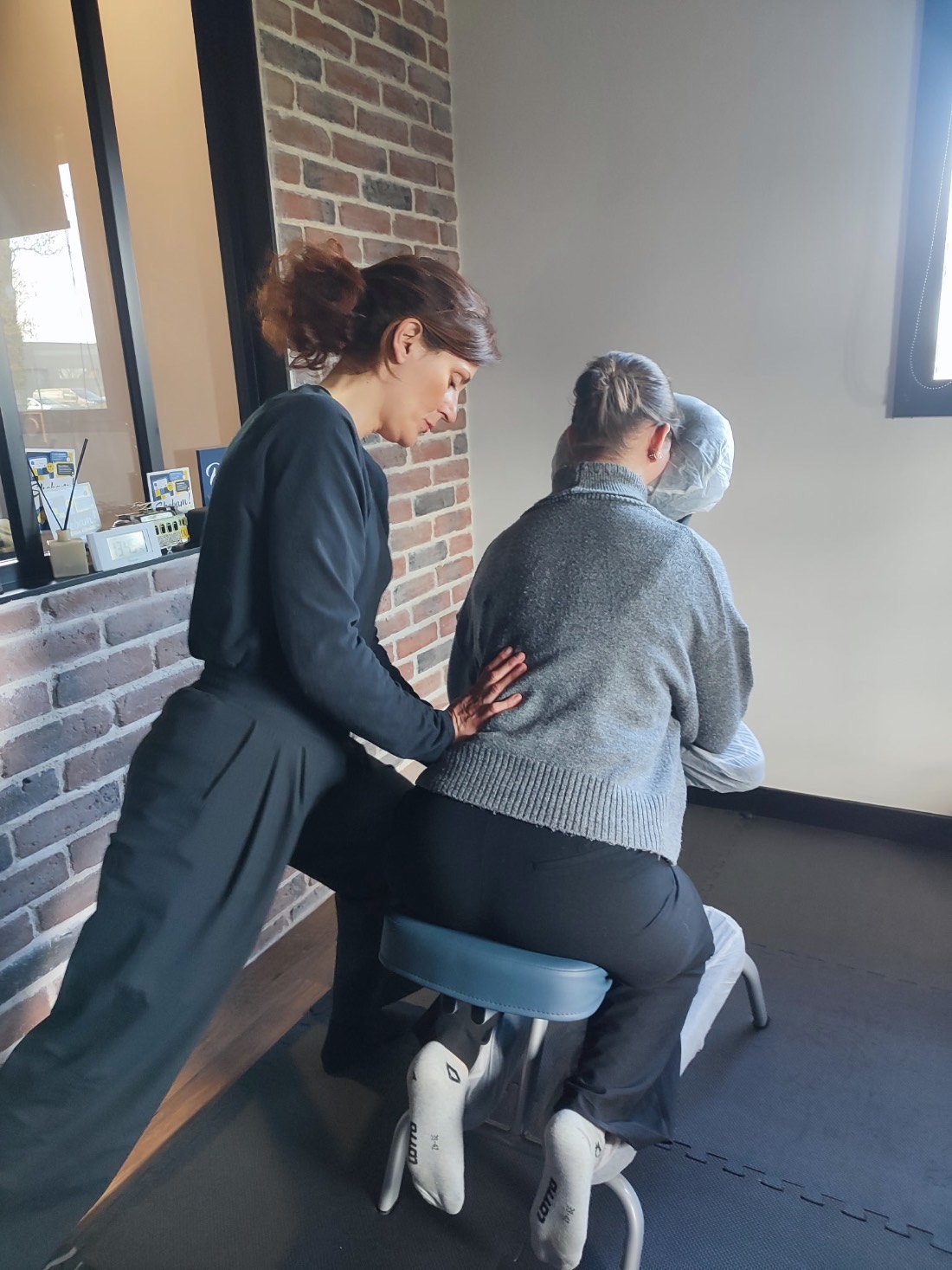 Solène Canivet en intervention de shiatsu sur chaise — travail sur le dos d'une personne assise, en entreprise