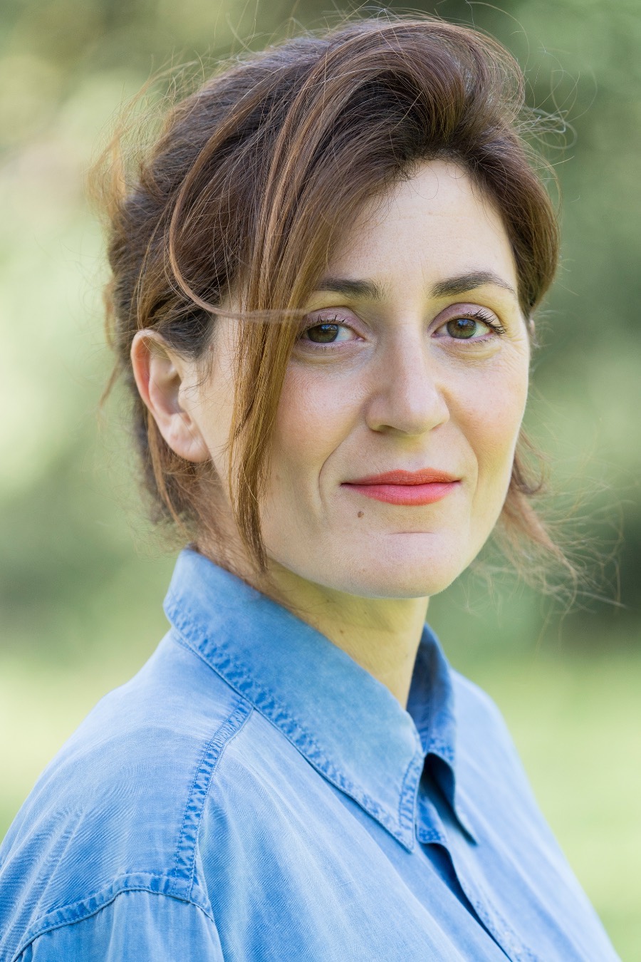 Portrait de Solène Canivet en chemise bleue, extérieur, lumière douce